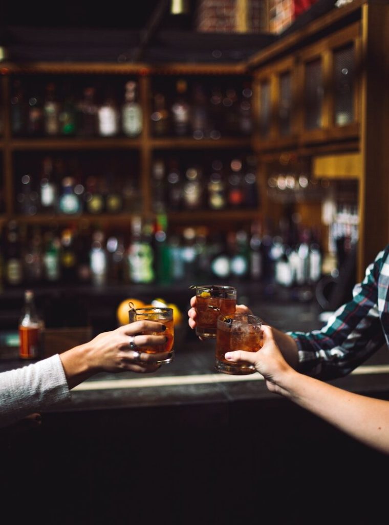 three person holding clear drinking glasses